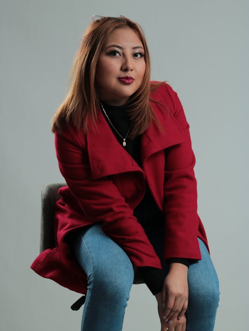 Sitting Model Woman in Red Coat and Jeans