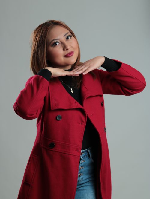 Free Studio portrait of a woman smiling with brown hair, wearing a red coat. Stock Photo