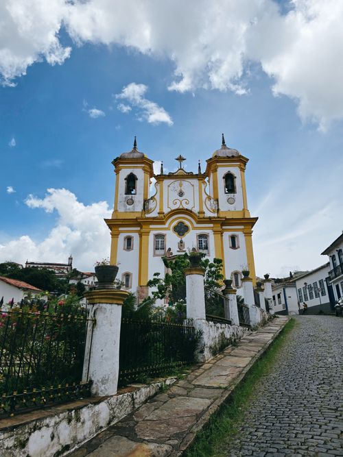 Free Scenic view of a historic Baroque church in Ouro Preto, Brazil, with a vibrant sky backdrop. Stock Photo