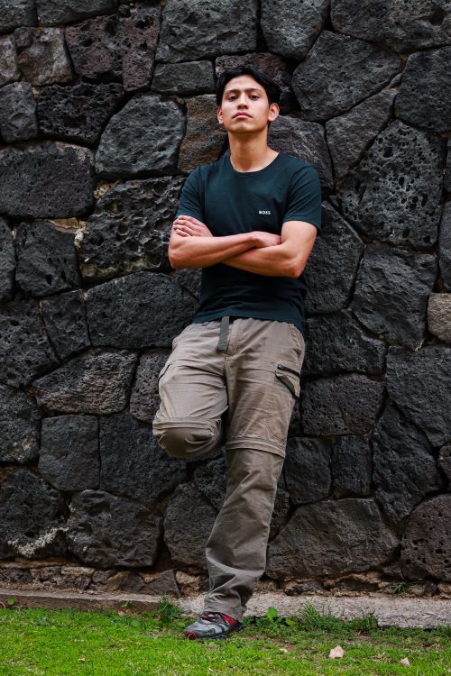 Free Man stands with arms crossed against a stone wall in Ciudad de México. Stock Photo