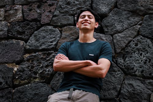 Smiling Man Leaning on Rocks Wall