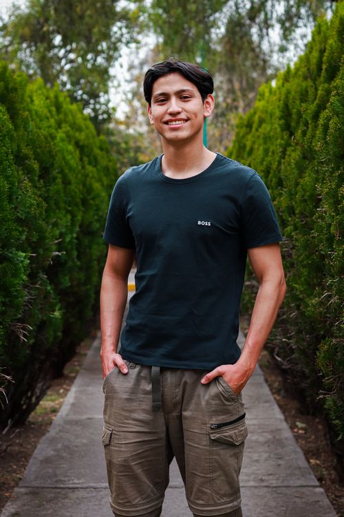 Free Young man in cargo pants and t-shirt smiling in a park in Ciudad de México, Mexico. Stock Photo