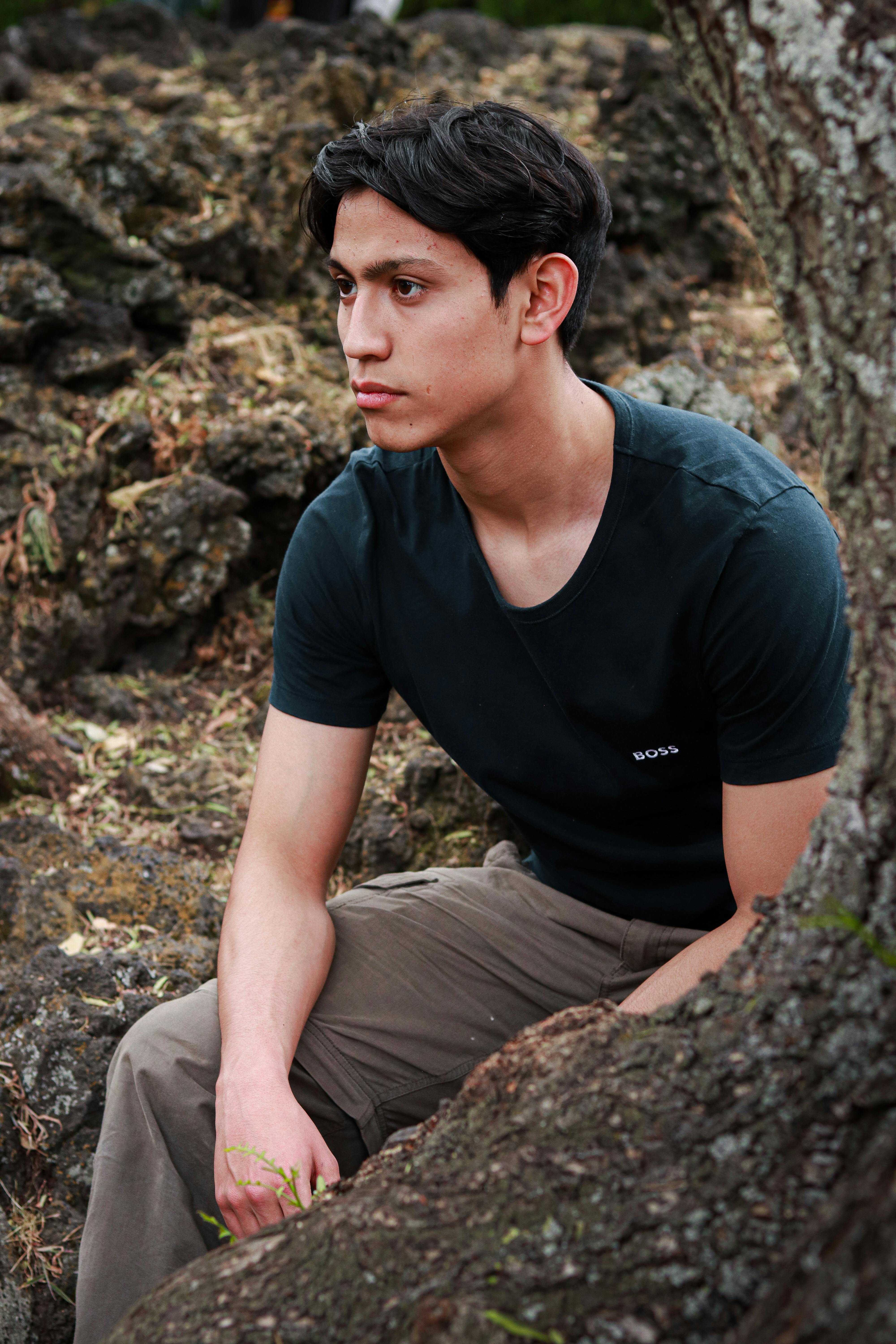 Stylish portrait of a man sitting outdoors in a natural setting in Mexico City.