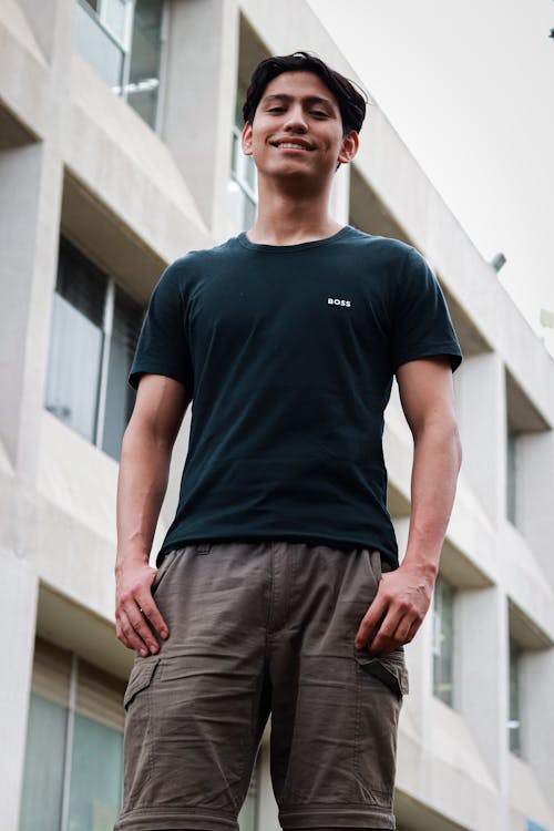 A young man standing in front of a building