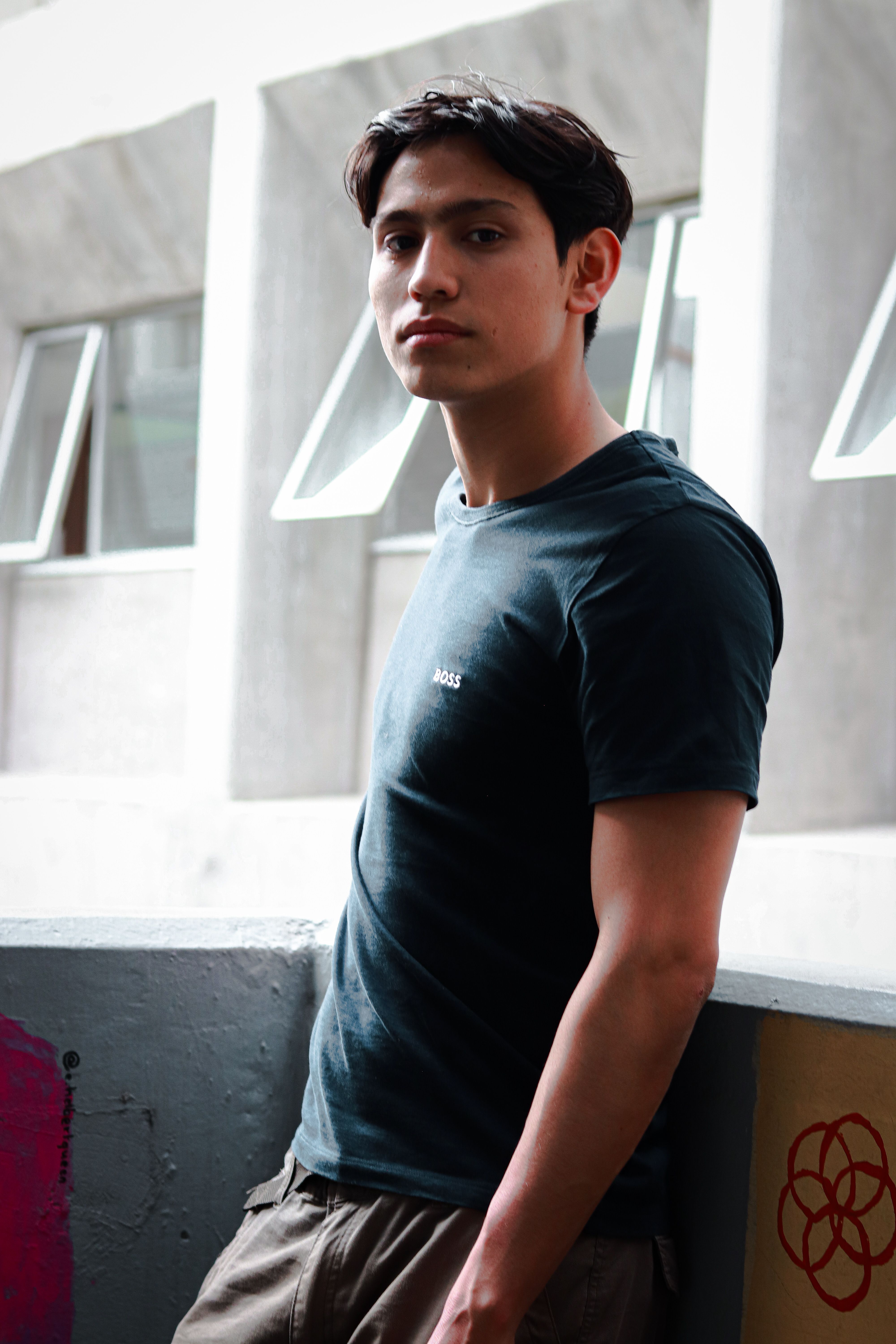 Portrait of a fashionable young man standing outdoors in Mexico City, showcasing modern casual style.