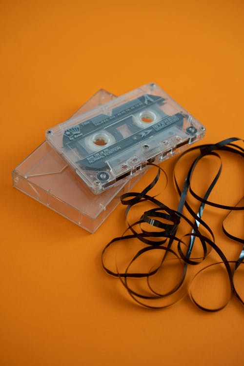 An old cassette tape with a cord on an orange background