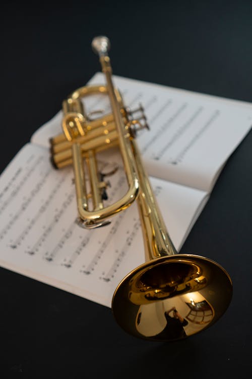 A trumpet is sitting on top of a sheet of music