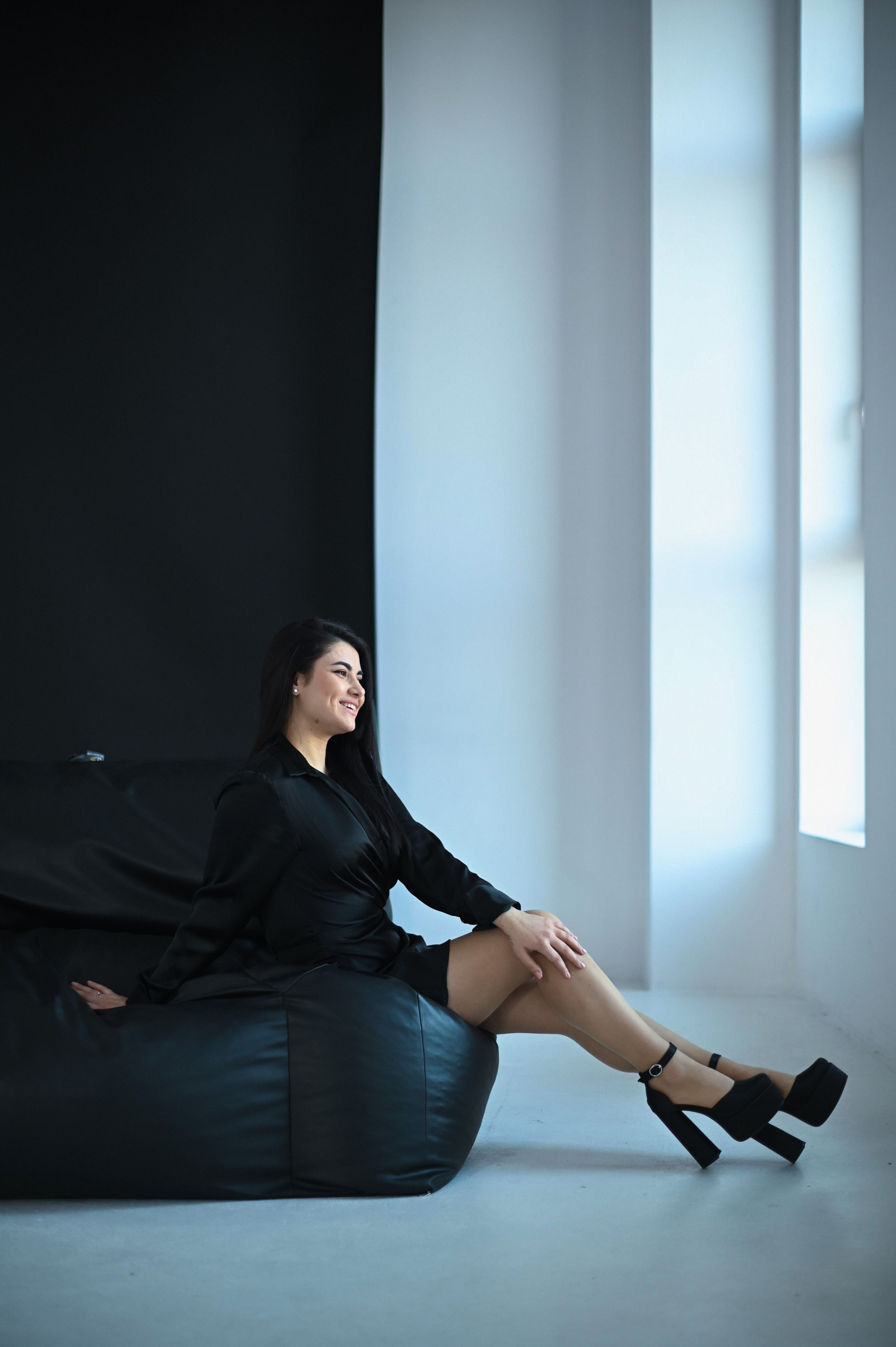 Stylish woman sitting on chair with gun · Free Stock Photo