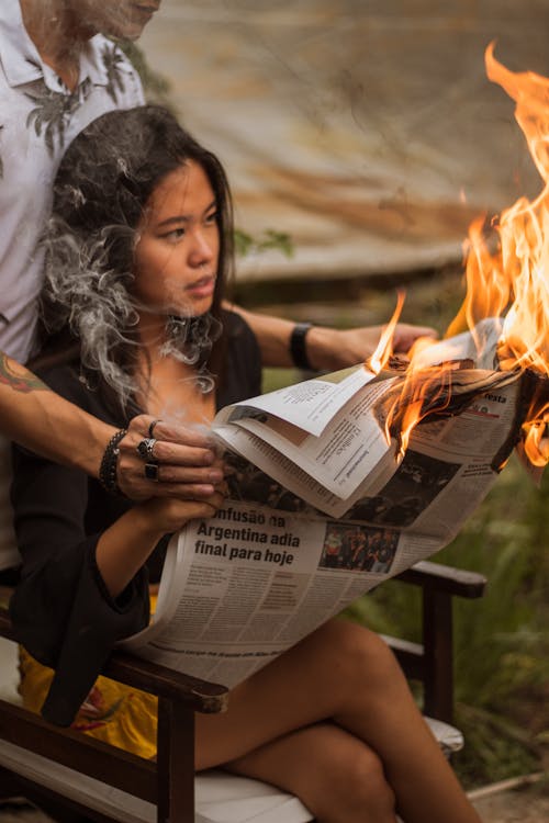 Free Woman Holding Burning Newspaper Stock Photo