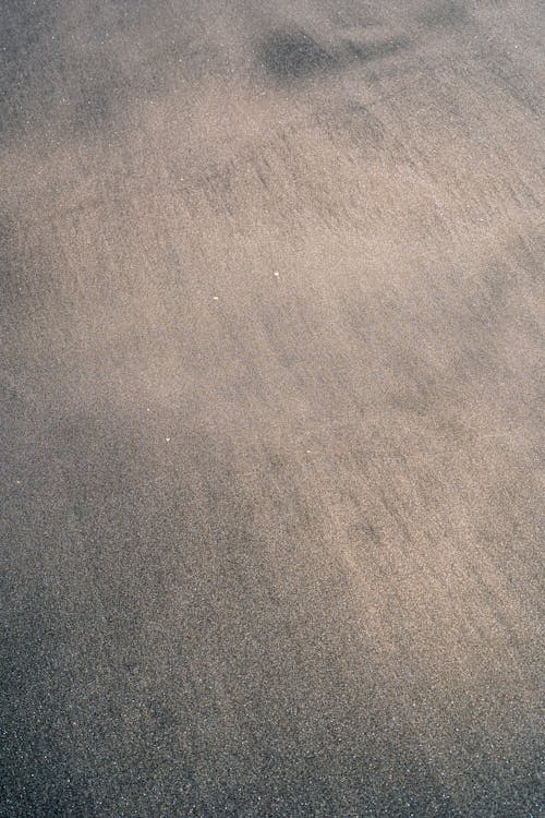 A person walking on a beach with a surfboard