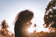 夕阳下，女人宁静的剪影捕捉了户外的静谧时刻