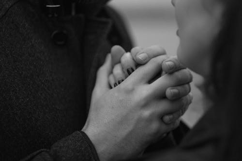 A black and white photo of a couple holding hands
