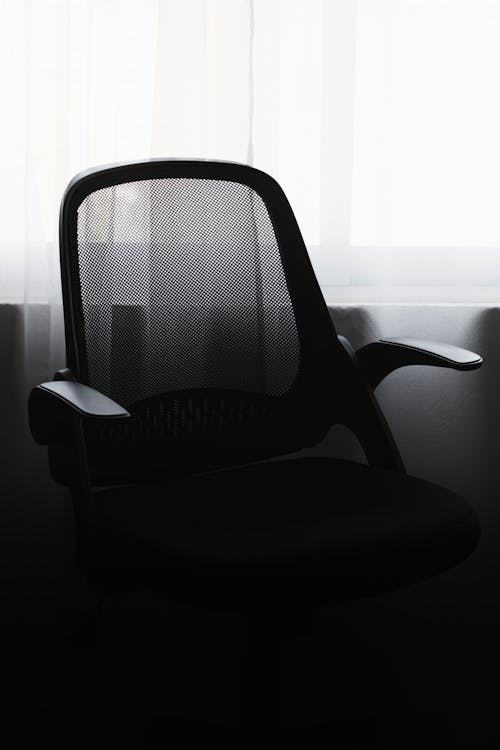 A black chair in front of a window