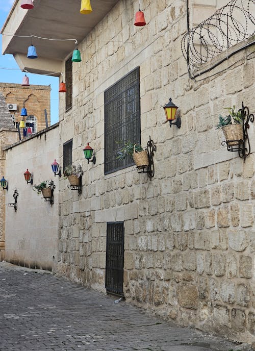 A stone wall with hanging lights and flowers
