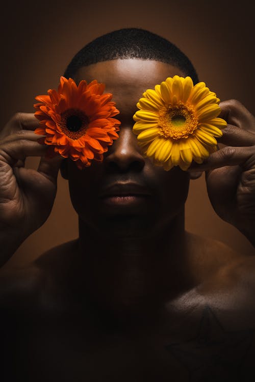 Man Holding Flowers in front of His Eyes 
