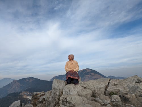 A woman sitting on top of a mountain