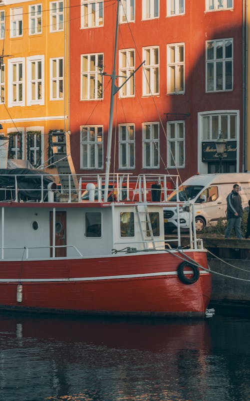 A red boat is parked in front of a building