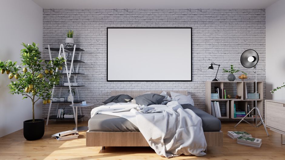 Kleines Studio mit weißem Klappbett in moderner Nische, geschlossener Front und kompaktem Sofa davor