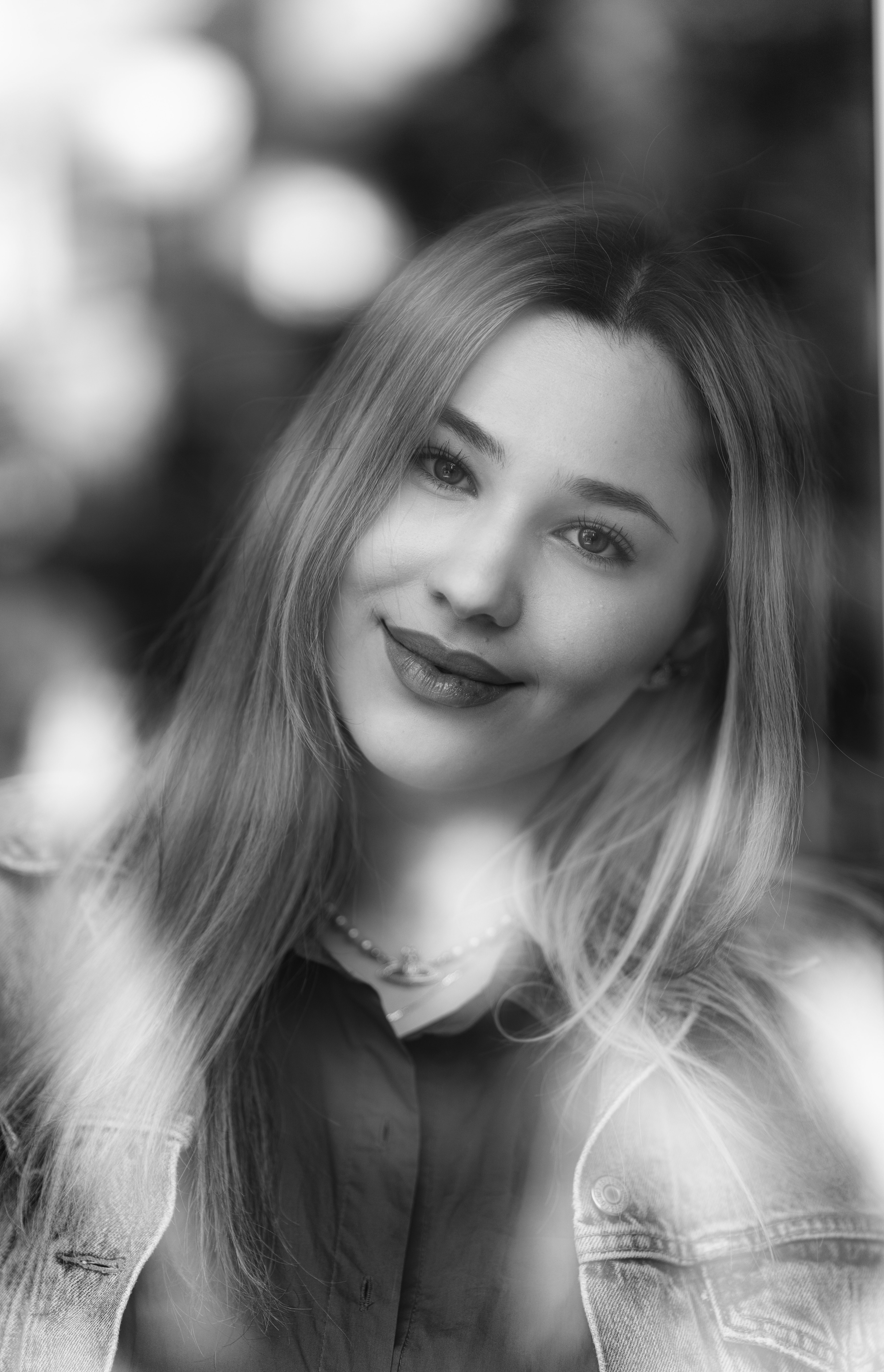 Charming black and white portrait of a smiling woman with blonde hair and selective focus.