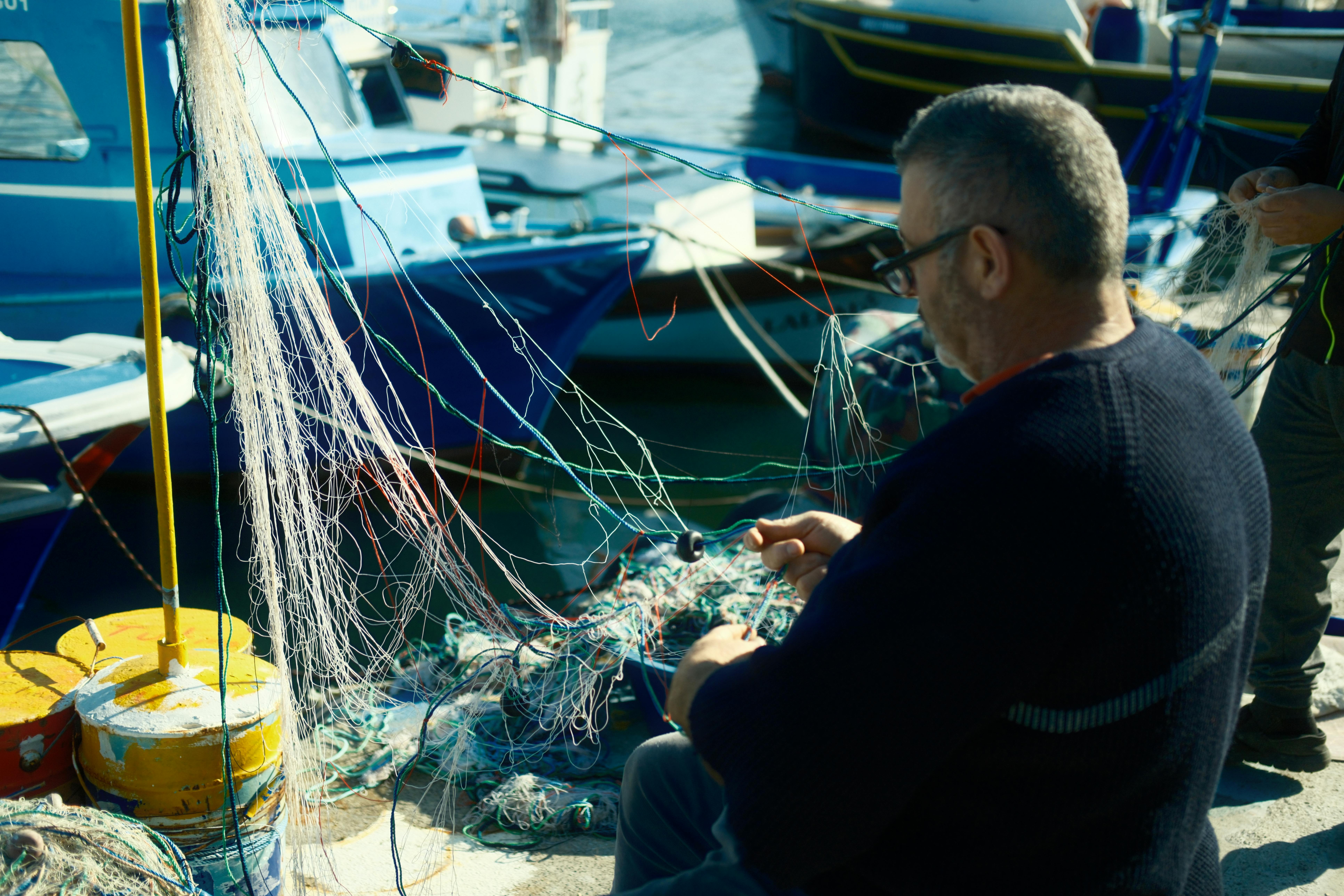 A man sitting on a boat with fishing nets