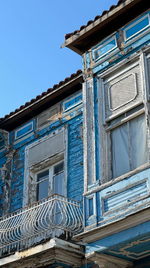 Free Close-up of a rustic blue house with vintage architecture and a weathered facade. Stock Photo