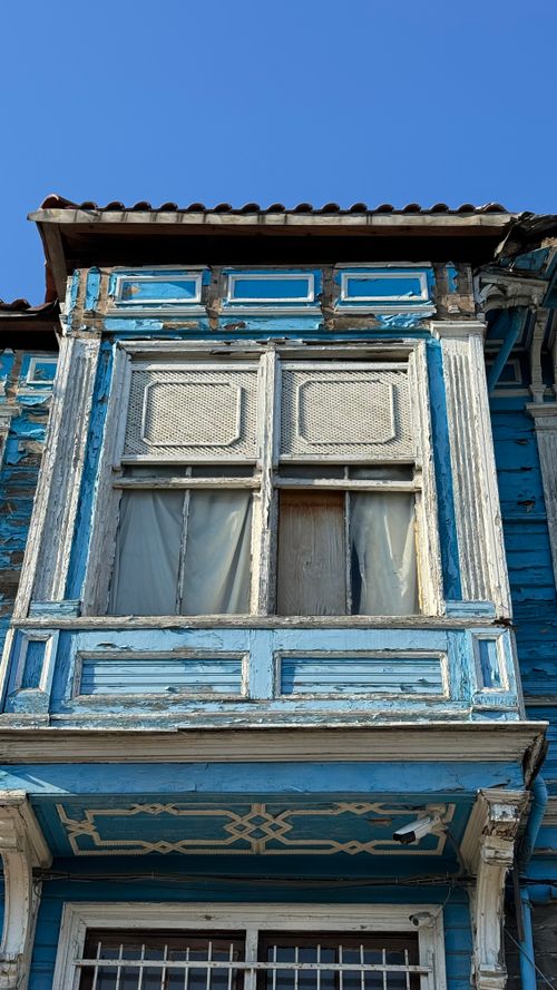 Free Close-up of damaged blue Ottoman-style wooden house against clear sky. Stock Photo