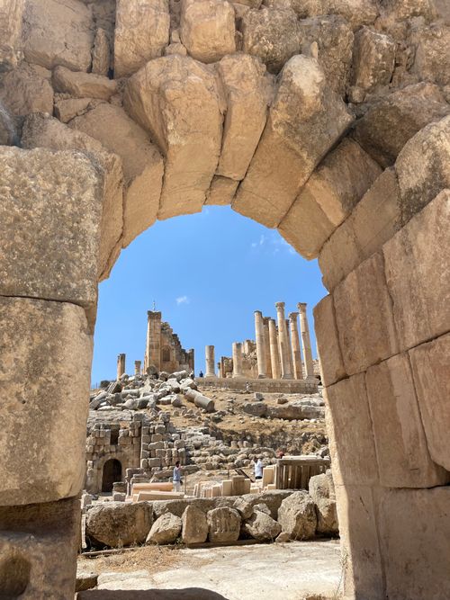 Free Discover the ancient ruins of Jerash through a majestic stone archway under the clear sky. Stock Photo