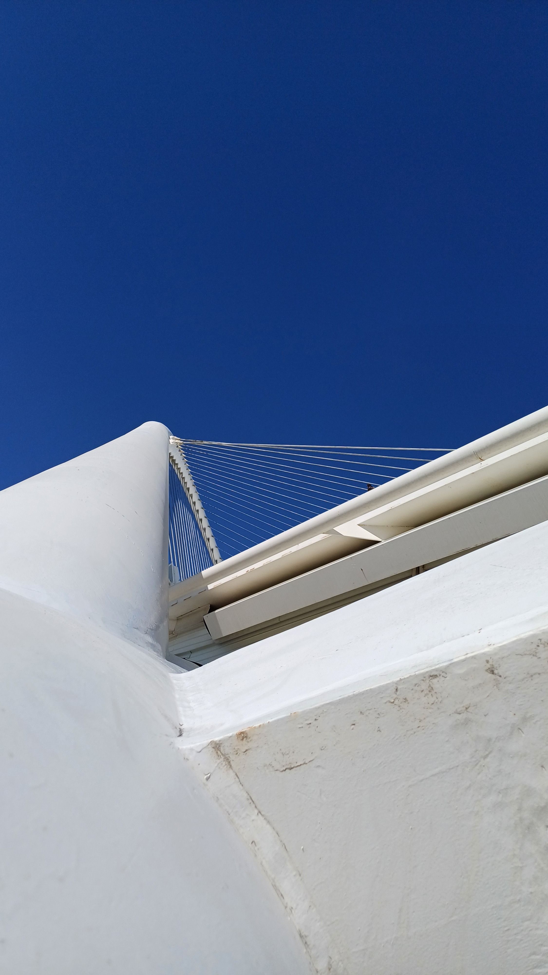 Low angle view of a modern bridge in Athens, Greece, with clear blue sky.