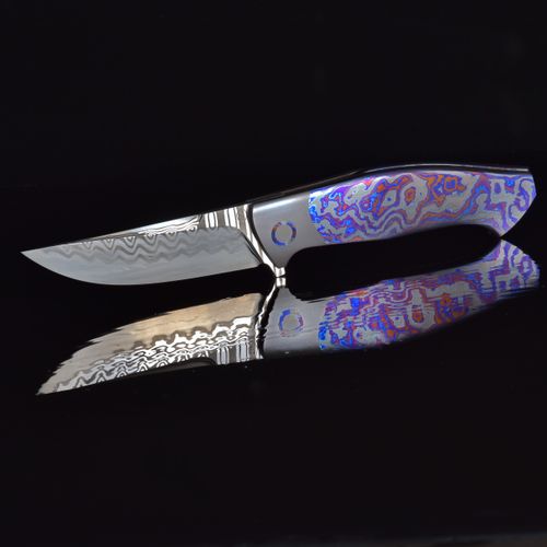 Free A stunning Damascus steel knife with a colorful handle and reflective blade, ideal for collectors. Stock Photo
