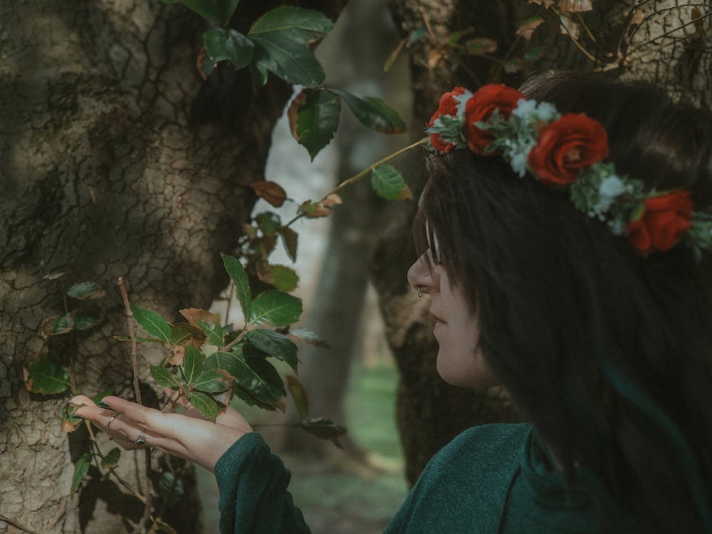 A woman with a flower crown looking at a tree