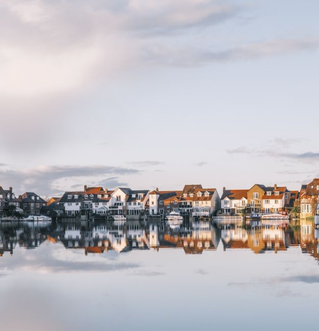 Charming houses reflecting in a tranquil lake in Abingdon, England.