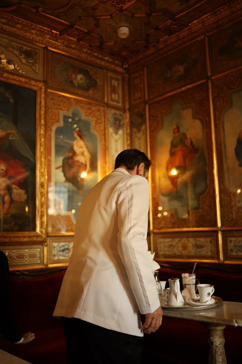 A man in a white jacket is serving coffee