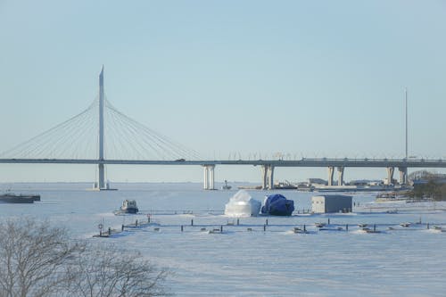 Cable Bridge over a Frozen River with Boats