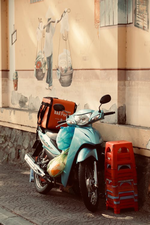 A motorcycle parked next to a wall with a painting on it