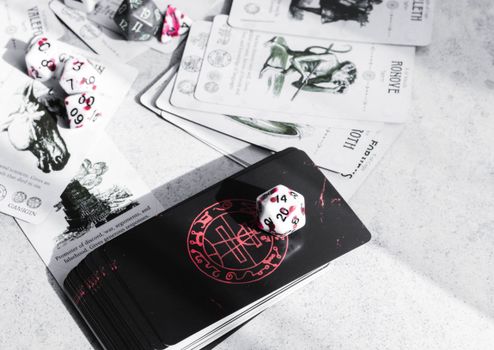 A collection of tarot cards and gaming dice on a tabletop, featuring mystical illustrations.