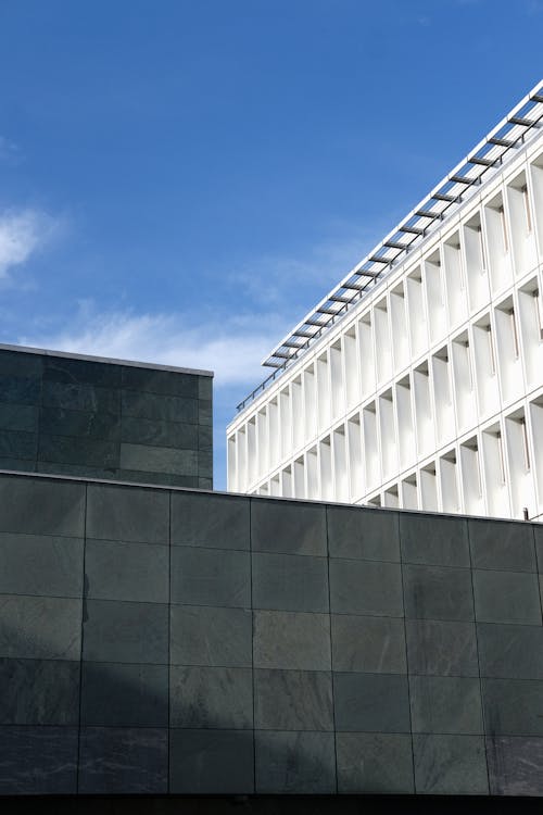 The building has a large glass wall and a blue sky