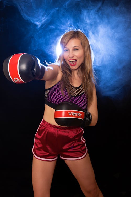 A woman in a red and black outfit with boxing gloves