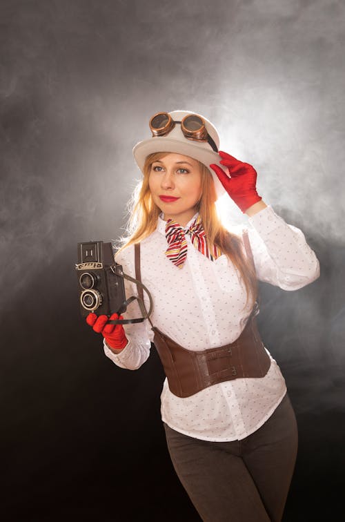 A woman in a steampunk costume holding a camera