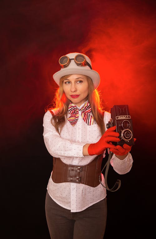 A woman in a steampunk costume holding a camera