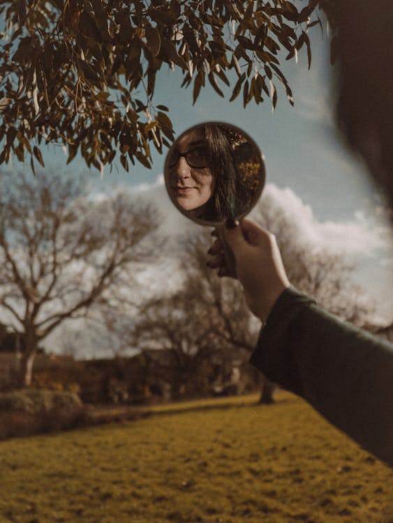 A person holding a mirror in front of their face