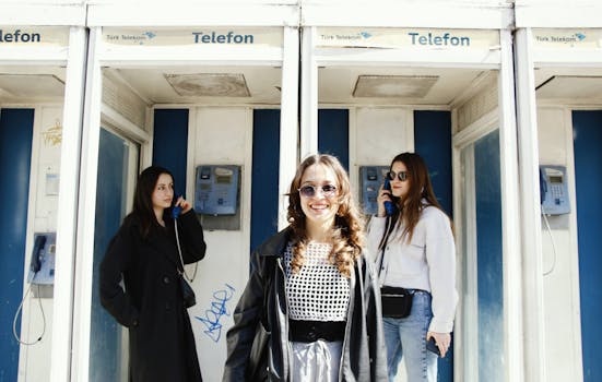 Urban portrait of three women in Ankara using Türk Telekom phone booths.