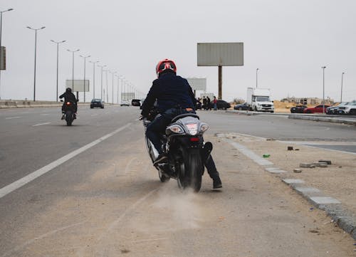 A man on a motorcycle rides down a road