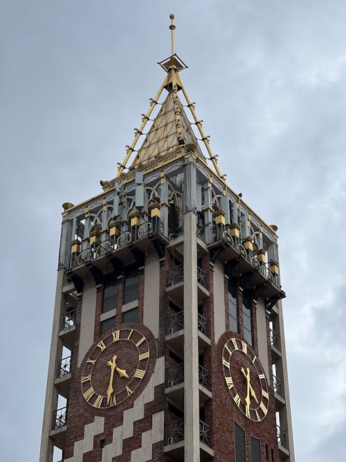 A tall clock tower with two gold clocks