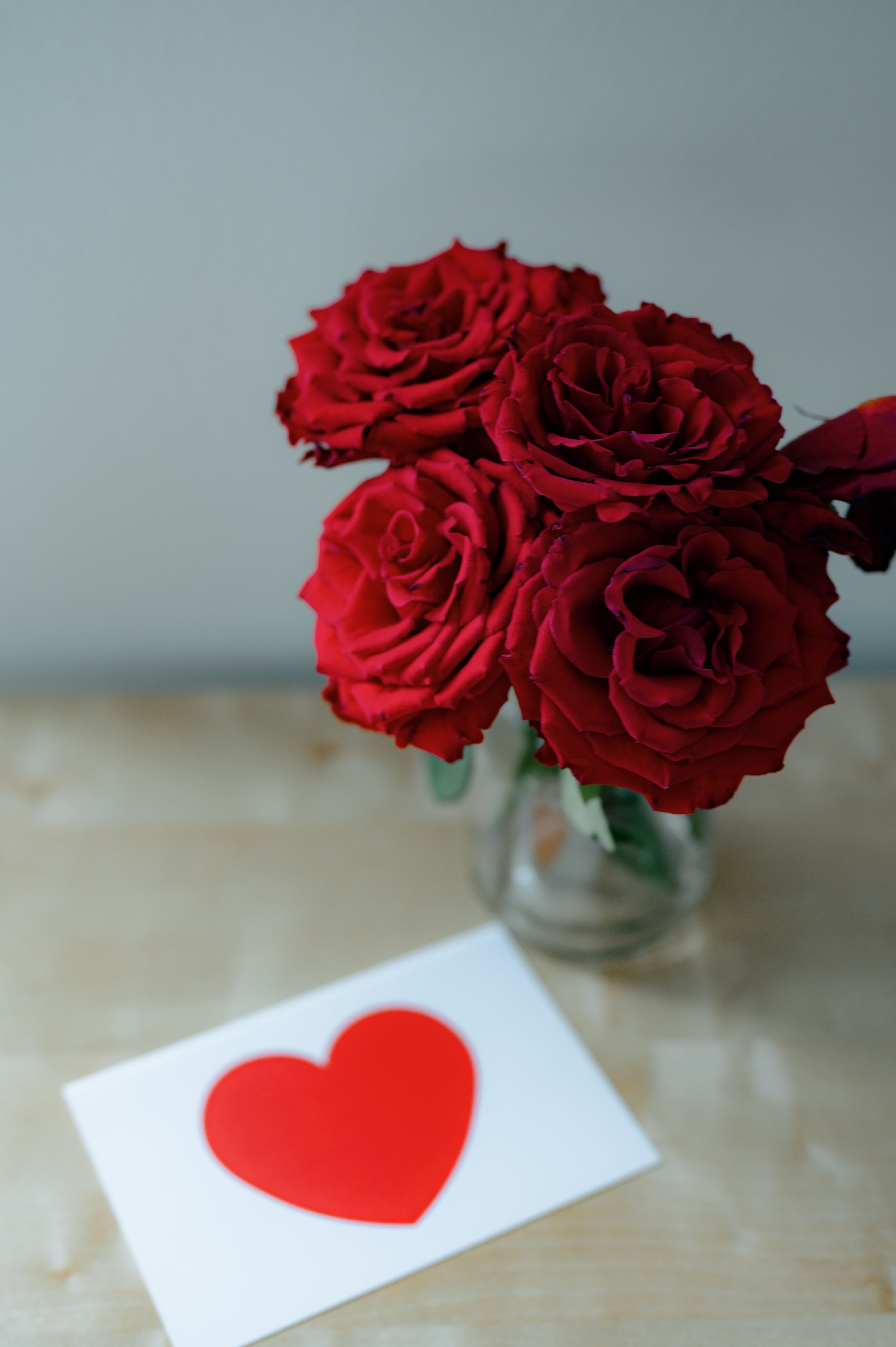 Greeting card and flower bouquet on a wooden table