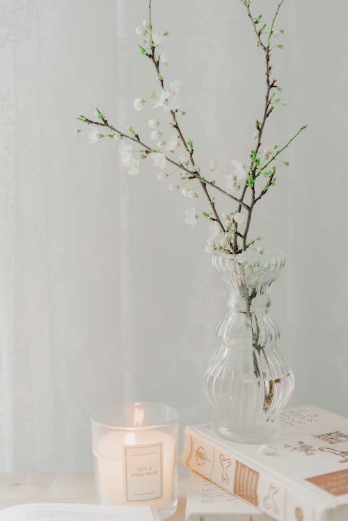 A vase with flowers and candles on a table