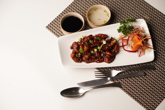 A delicious gourmet meat dish with fresh vegetables and flavorful sauces, captured in bright lighting.