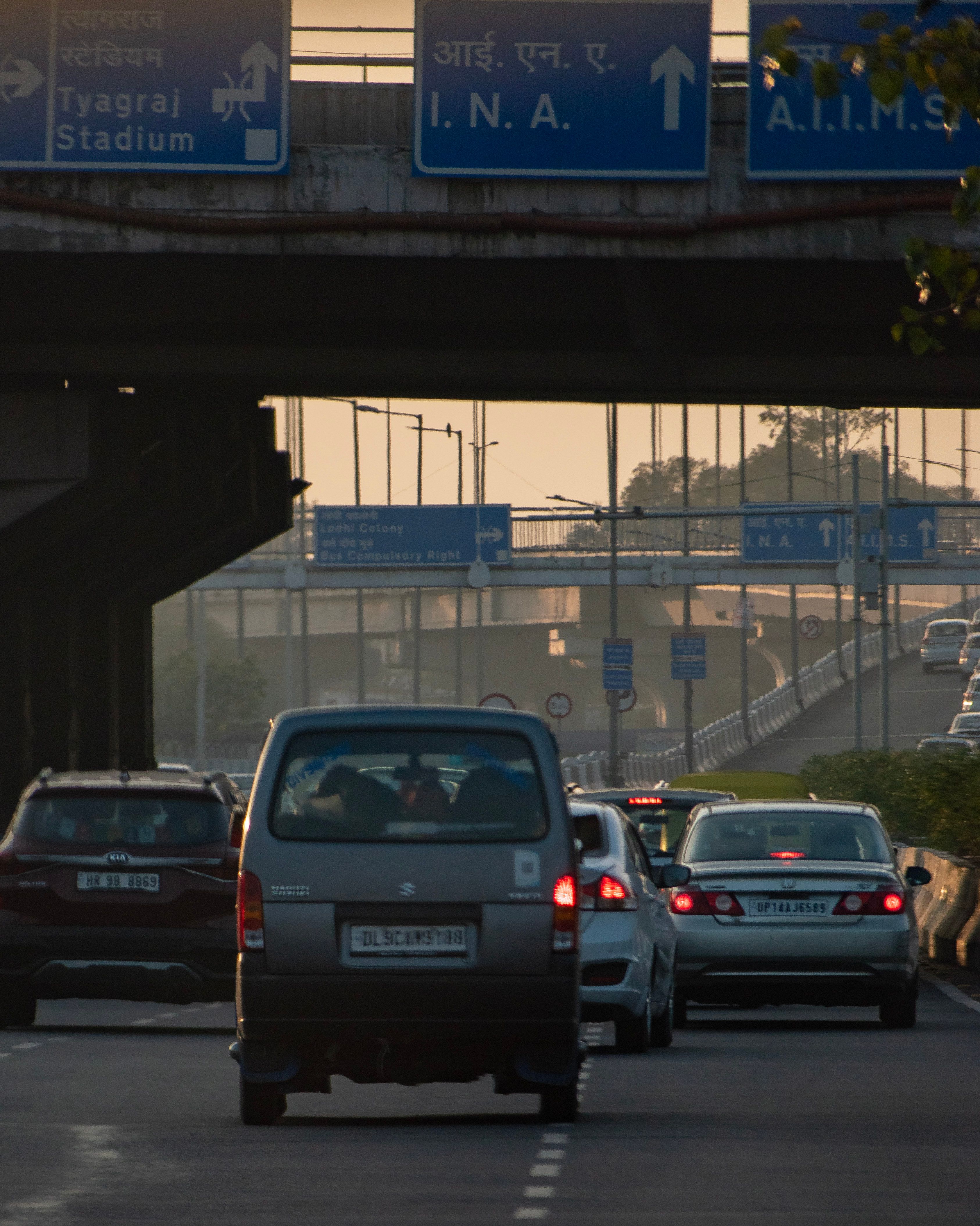 A car is driving on the road under a highway sign · Free Stock Photo
