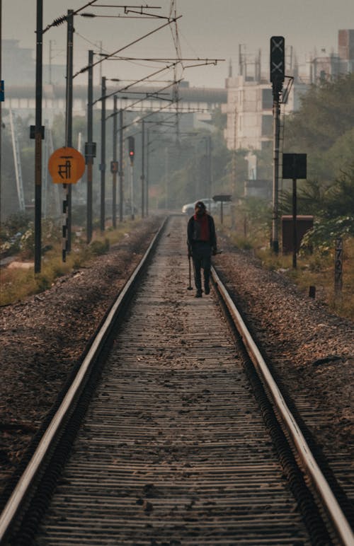 Back View of a Man Walking on the Railway 