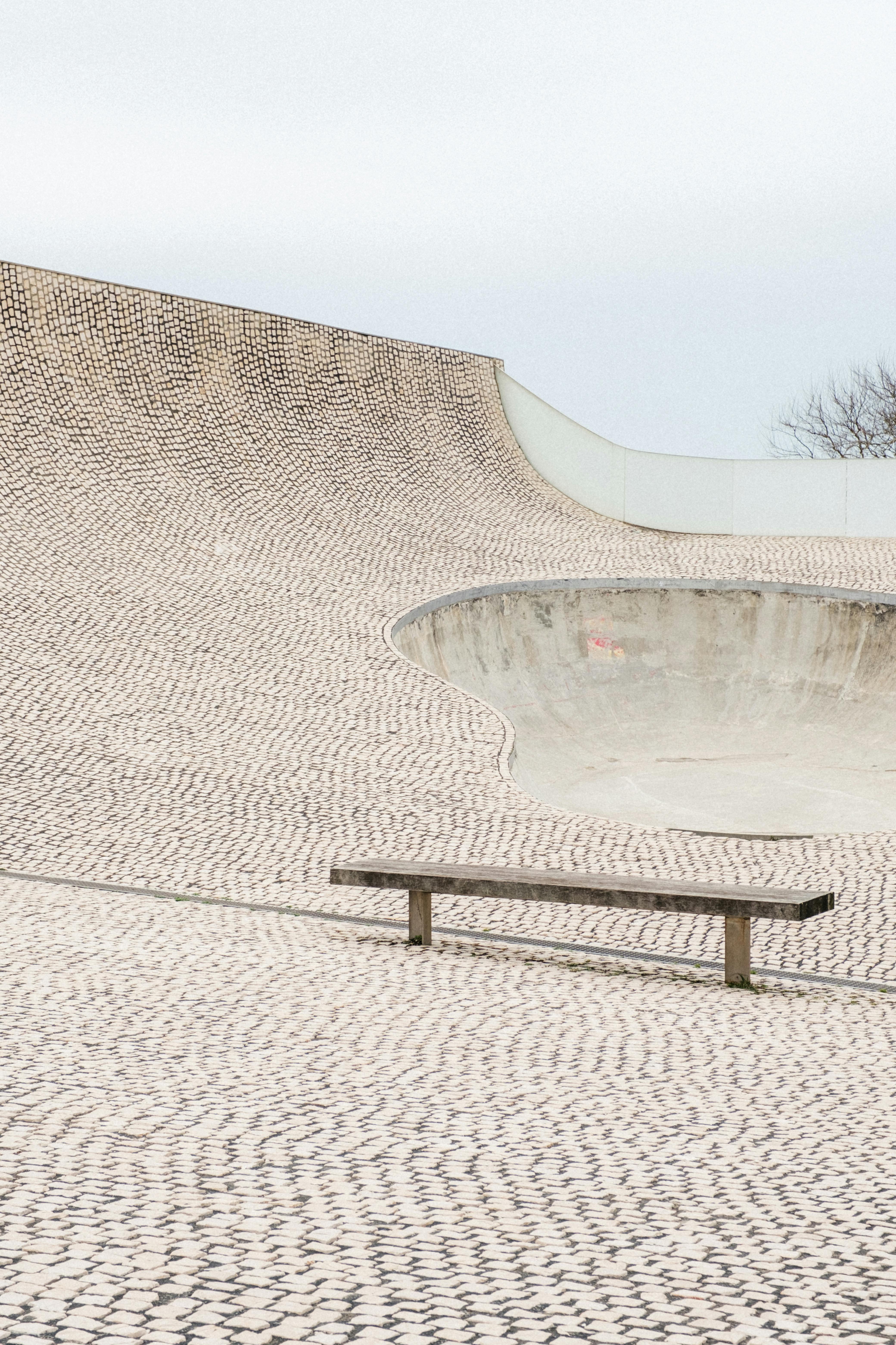Wooden bench on a cobblestone skatepark in Biarritz, France. Ideal for urban lifestyle and outdoor activities.