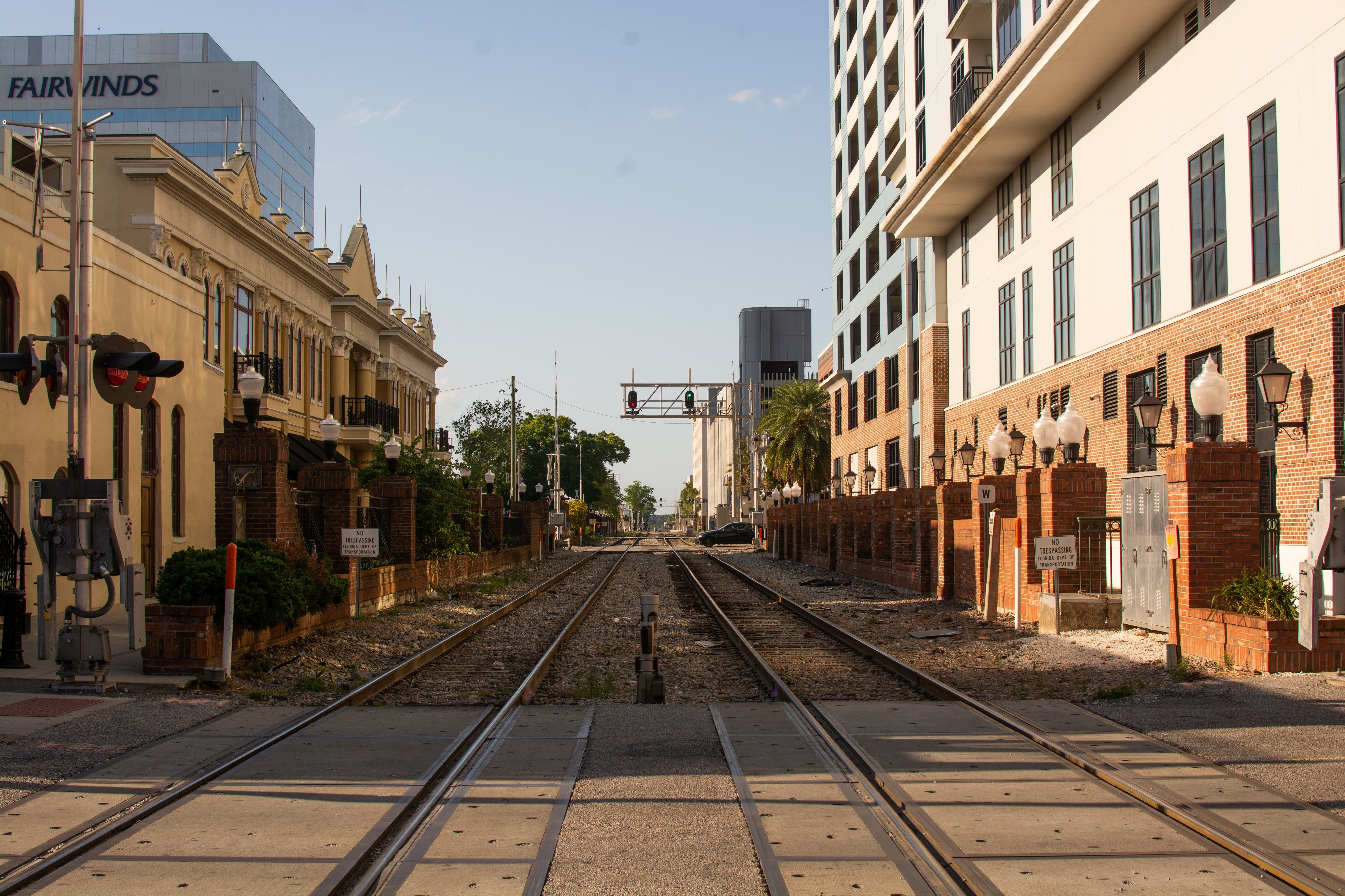 View of railway tracks flanked by urban architecture under a clear sky.